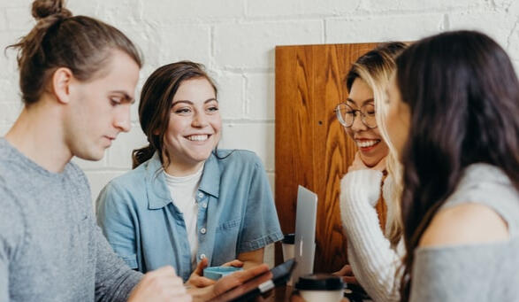 Four people smiling and talking; provided by generous artist at Unsplash.com
